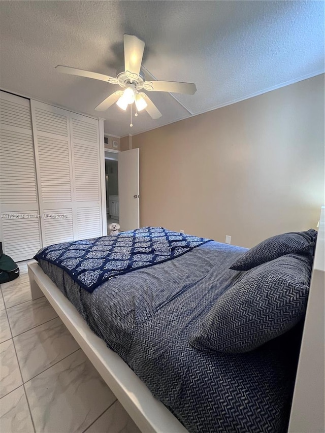 bedroom with ceiling fan, a textured ceiling, and a closet