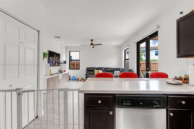 kitchen featuring ceiling fan, dishwasher, light tile patterned flooring, and dark brown cabinetry