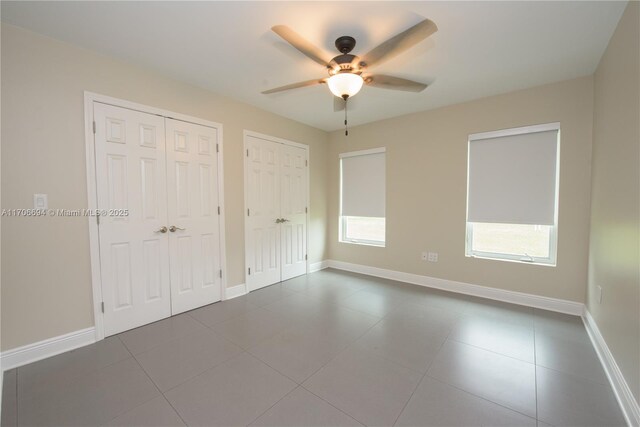 bedroom with ceiling fan and multiple closets