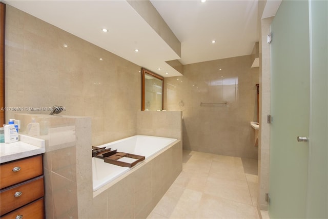 full bathroom with vanity, tile walls, a bath, tile patterned floors, and a shower with door