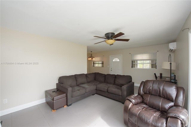 living area featuring an AC wall unit, light tile patterned flooring, a ceiling fan, and baseboards