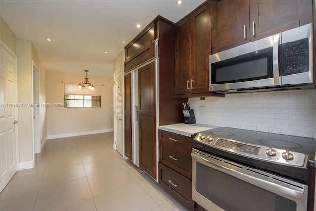 kitchen featuring appliances with stainless steel finishes, dark brown cabinets, decorative backsplash, and light tile patterned floors