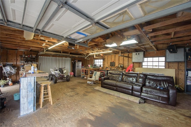 garage featuring stainless steel fridge and a workshop area