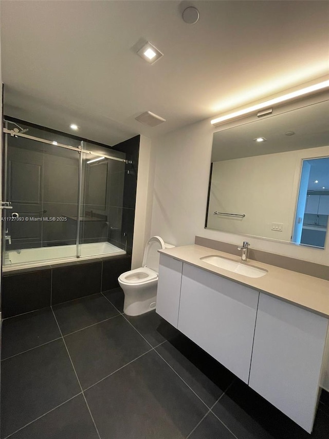 full bathroom with shower / bath combination with glass door, vanity, toilet, and tile patterned flooring