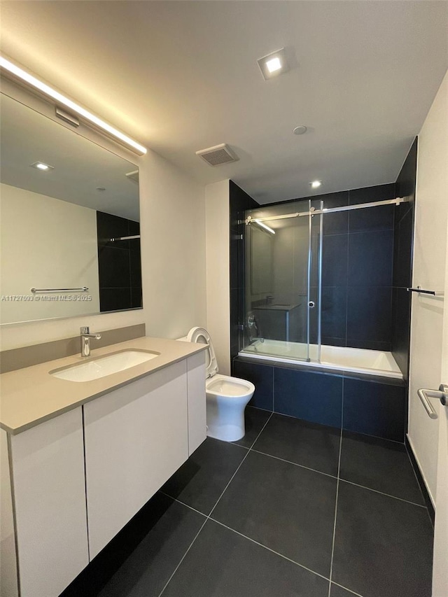 full bathroom featuring toilet, tile patterned floors, enclosed tub / shower combo, and vanity