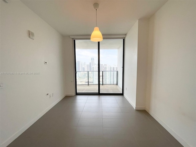 tiled spare room featuring a wall of windows