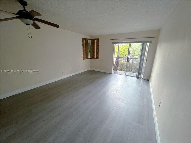 unfurnished living room with brick wall and dark hardwood / wood-style flooring