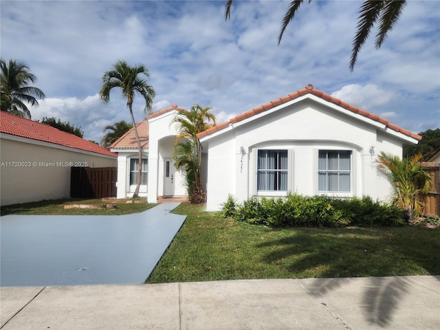 mediterranean / spanish home with a front lawn