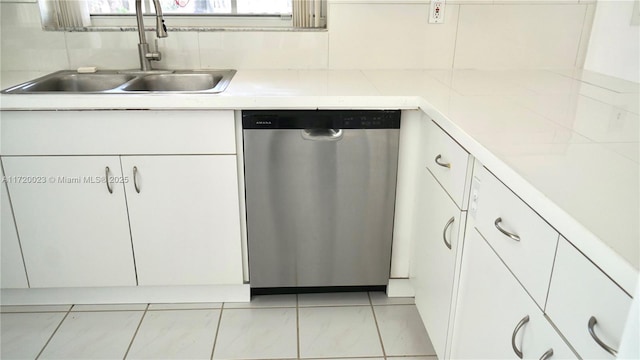 kitchen featuring white cabinets, tasteful backsplash, sink, light tile patterned flooring, and stainless steel dishwasher