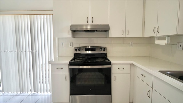 kitchen with white cabinetry, backsplash, and stainless steel electric range