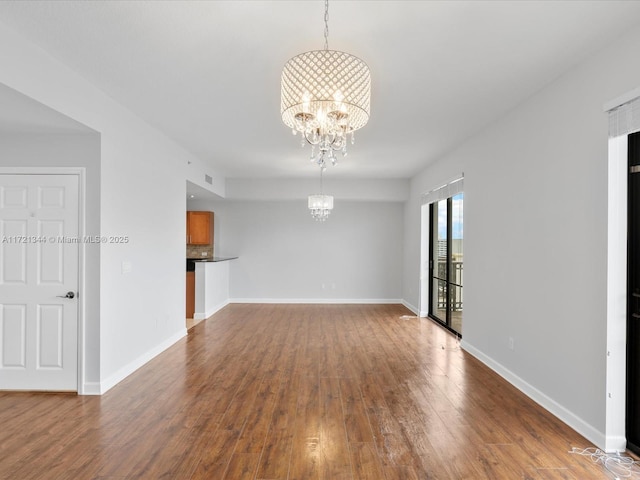 unfurnished room featuring an inviting chandelier and hardwood / wood-style flooring