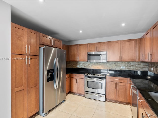 kitchen with decorative backsplash, light tile patterned floors, and appliances with stainless steel finishes