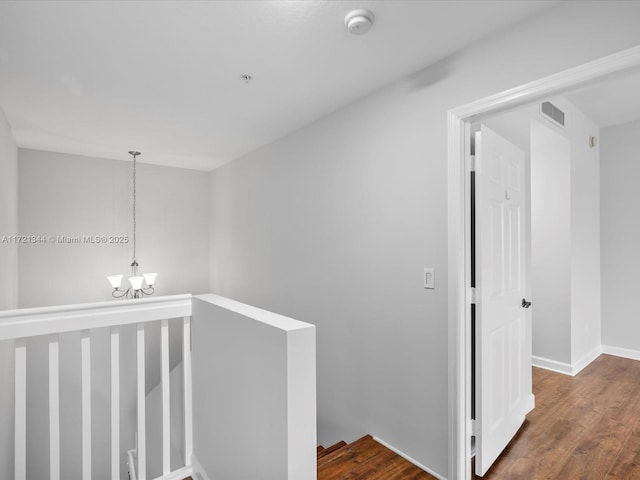 hall featuring dark hardwood / wood-style floors and an inviting chandelier