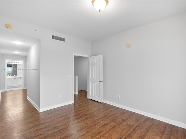 spare room featuring dark wood-type flooring