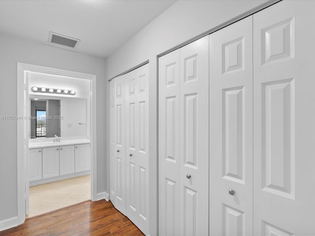 hallway with dark wood-type flooring and sink