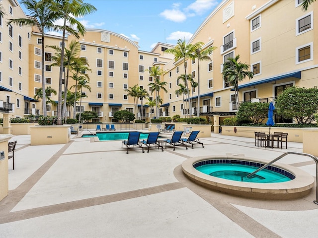 view of swimming pool with a hot tub and a patio area