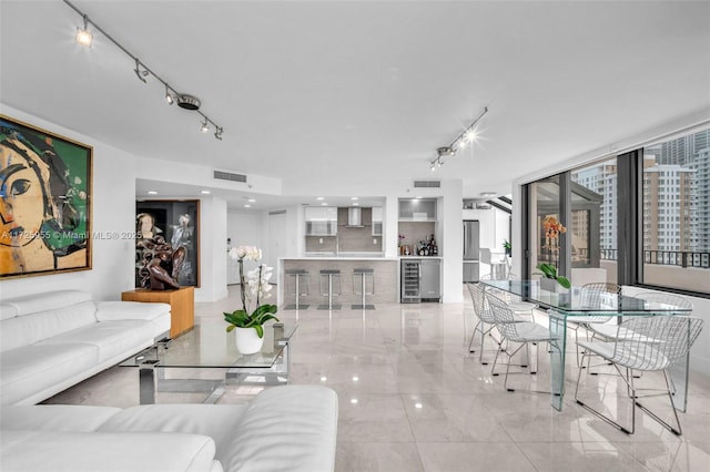 living room featuring wine cooler, bar area, and floor to ceiling windows