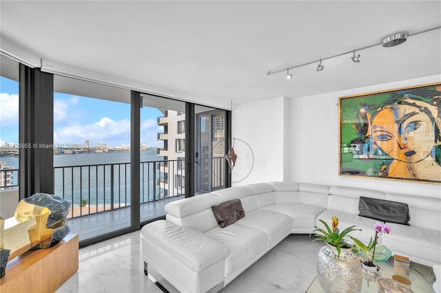 living room featuring a water view, a wall of windows, and a wealth of natural light