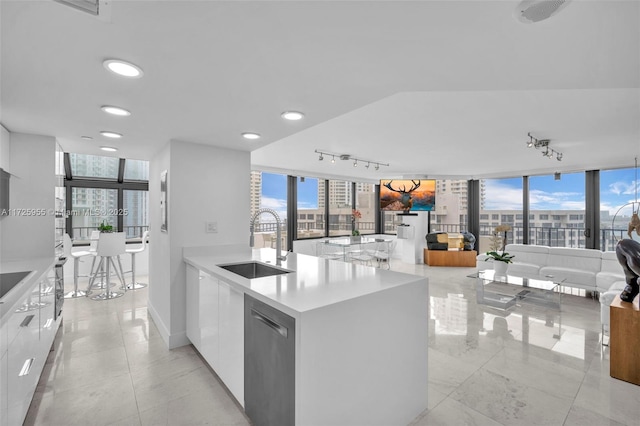 kitchen with sink, an inviting chandelier, white cabinetry, expansive windows, and appliances with stainless steel finishes