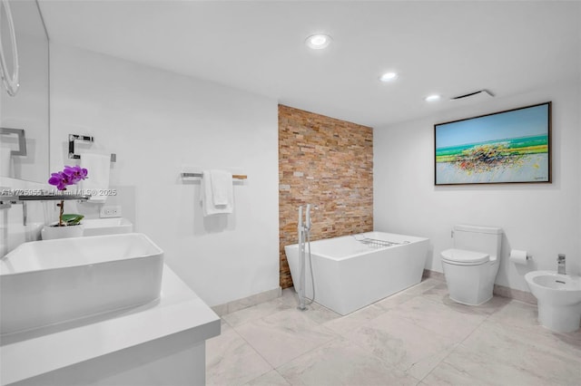 bathroom featuring toilet, vanity, a bidet, and a bathing tub