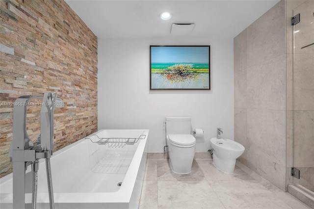 bathroom featuring a bidet, toilet, and a bathing tub