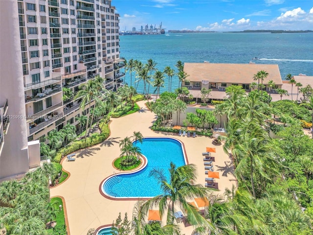 view of swimming pool featuring a water view and a patio area