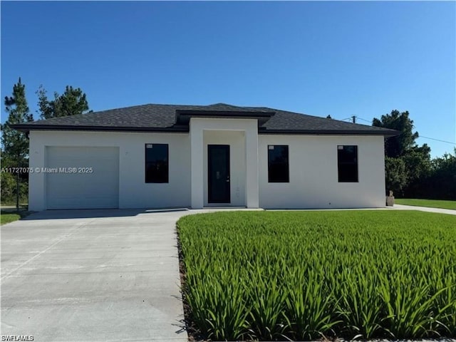 view of front of property featuring a front yard and a garage