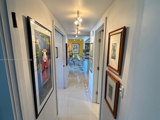 corridor featuring light tile patterned flooring and track lighting