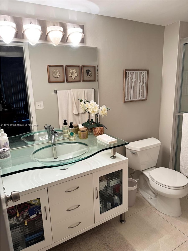 bathroom with toilet, tile patterned floors, and vanity