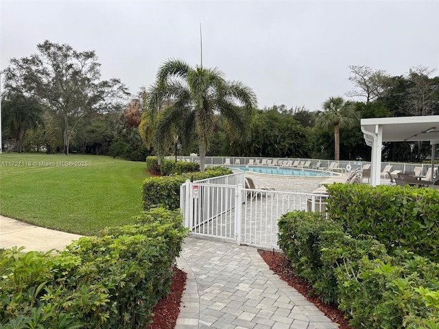 view of pool featuring a lawn