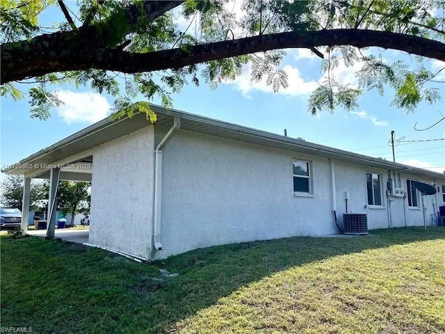 view of side of home featuring central AC unit and a yard