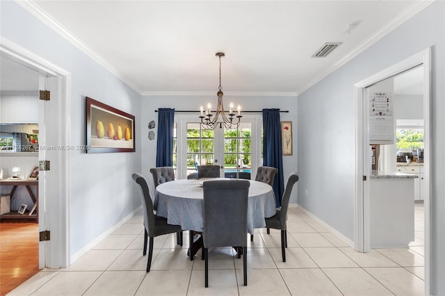 tiled dining space with a wealth of natural light, an inviting chandelier, and ornamental molding