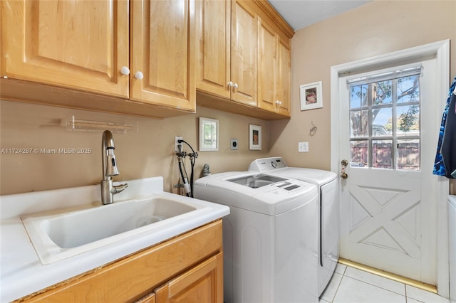 laundry room with light tile patterned floors, washing machine and dryer, sink, and cabinets