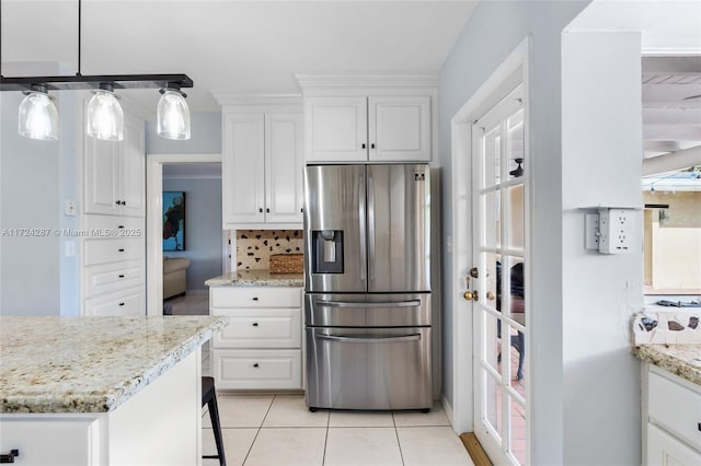 kitchen featuring stainless steel refrigerator with ice dispenser, white cabinets, and hanging light fixtures