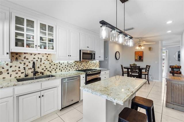 kitchen featuring ceiling fan, stainless steel appliances, white cabinets, and sink