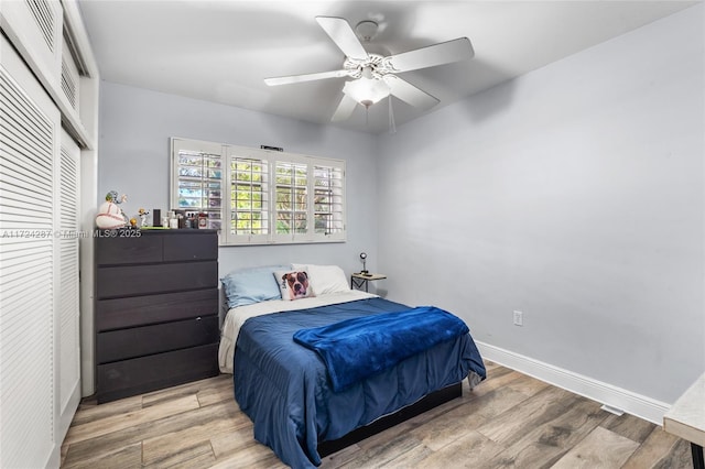 bedroom with ceiling fan, a closet, and wood-type flooring