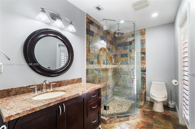 bathroom featuring toilet, vanity, and walk in shower