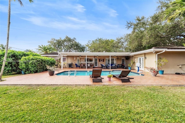 view of pool featuring ceiling fan, a lawn, french doors, and a patio