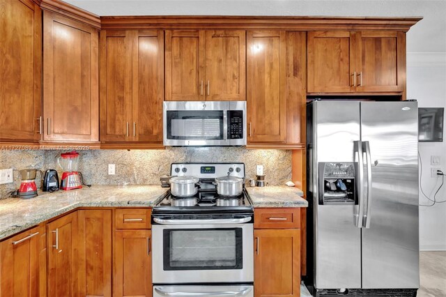 kitchen with stainless steel dishwasher, decorative light fixtures, backsplash, and light stone counters