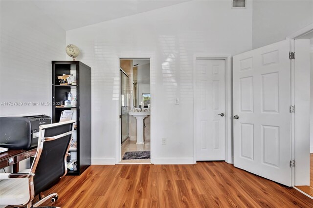 laundry room with light tile patterned floors, stacked washer and clothes dryer, and water heater