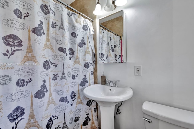 bathroom with curtained shower and toilet