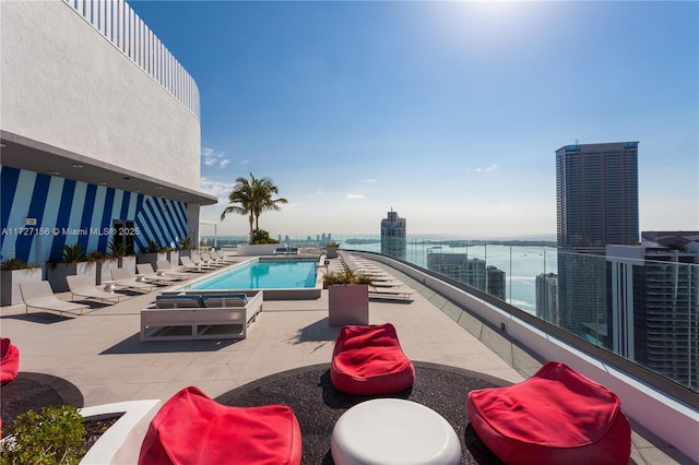 view of swimming pool with a water view and a patio