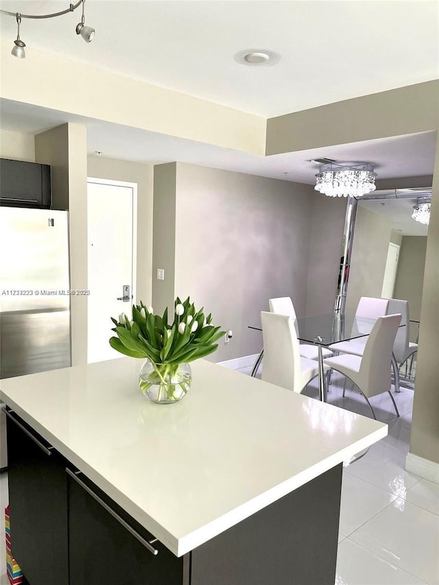 kitchen featuring fridge, light tile patterned flooring, and a center island