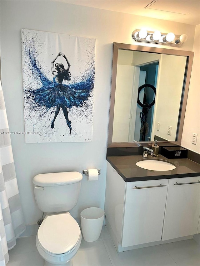 bathroom with toilet, vanity, and tile patterned flooring