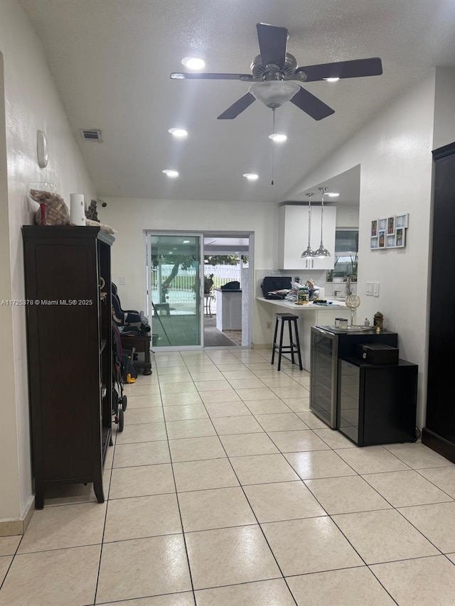 kitchen featuring lofted ceiling, ceiling fan, and light tile patterned flooring