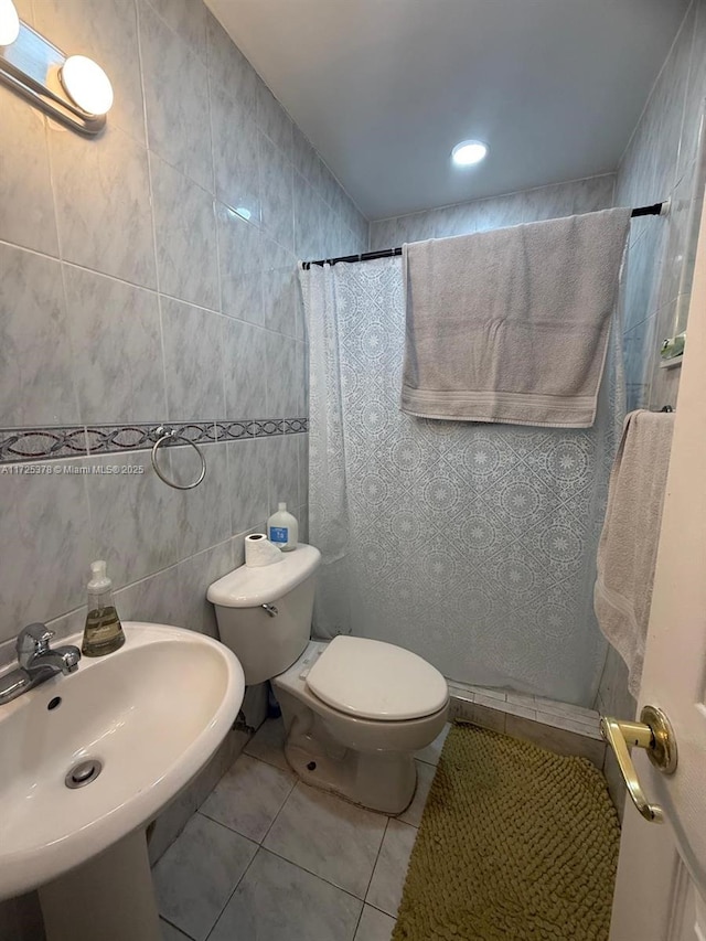 bathroom with tile patterned floors, sink, tile walls, toilet, and a shower with shower curtain