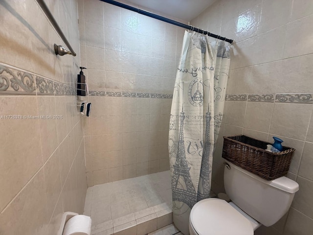 bathroom featuring toilet, tile walls, and curtained shower