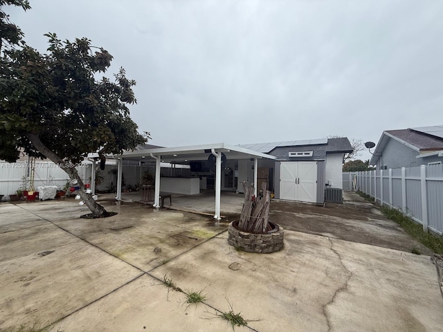 rear view of house with central AC, a shed, and solar panels