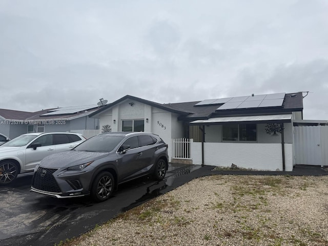 ranch-style house featuring solar panels