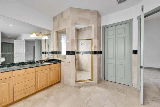 bathroom featuring a stall shower, a closet, visible vents, vanity, and tile walls